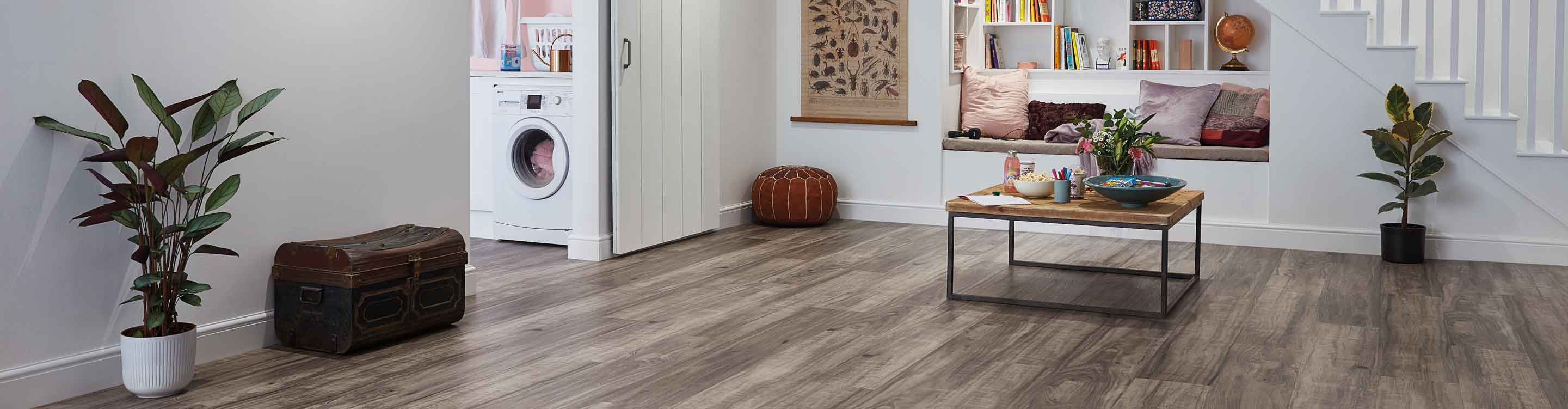 wood look Vinyl flooring in modern basement playroom with barn door to laundry space